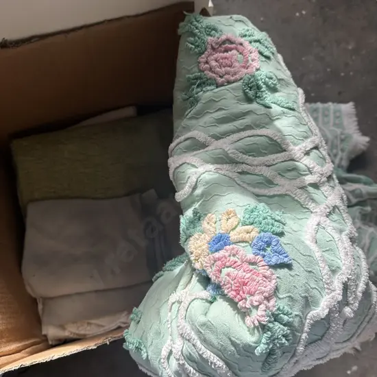 Large box of towels and bedding.