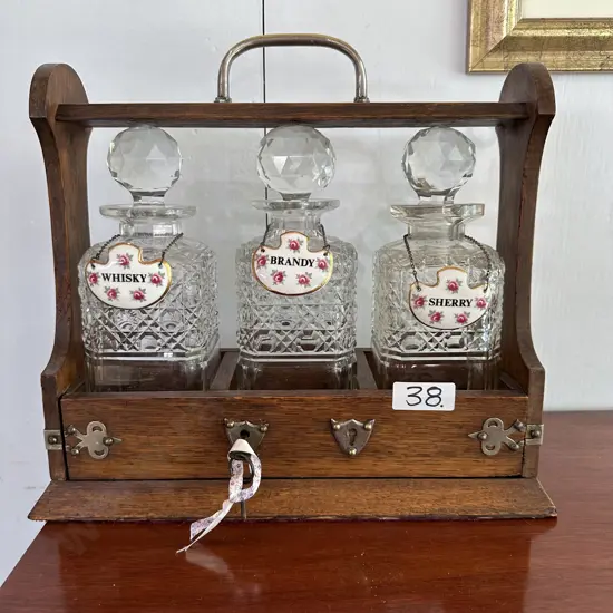 Oak cased Tantalus working mechanism, some minor chips to decanters