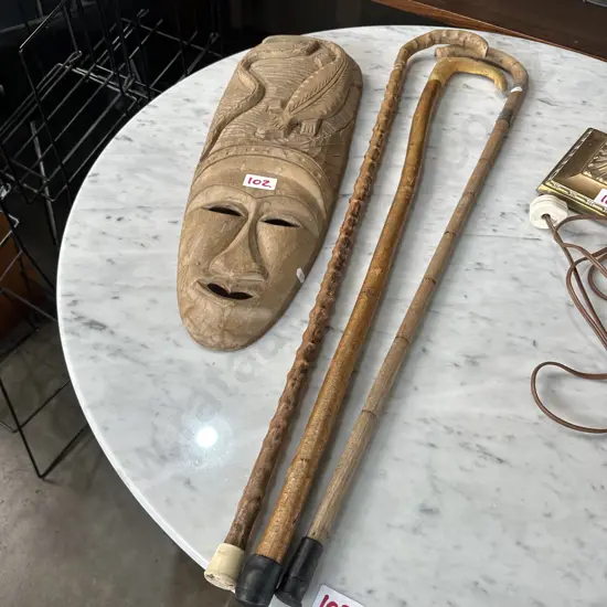 Carved mask and three walking sticks