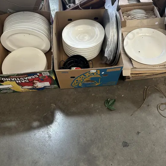 Three boxes plates, pizza trays, paella dishes.