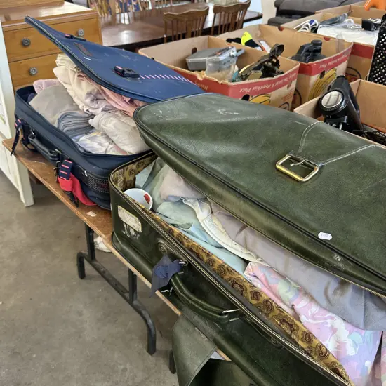 Two suitcases of bedding, towels and cups.