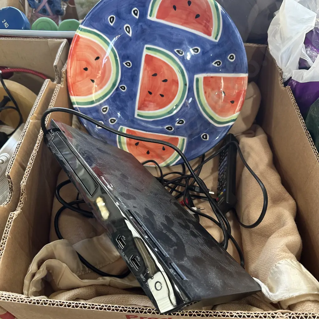 Box with blanket, tv,  blue-ray player and colourful fruit bowl. Image 1++