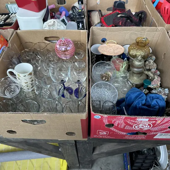 Two boxes including weighted neck wrap, glasses and ornaments etc.