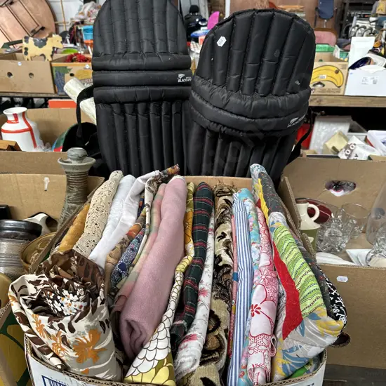Box of vintage material plus black caps branded cricket pads.