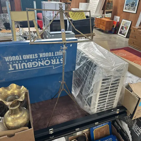 Music stand and instrument case plus colourful picture.