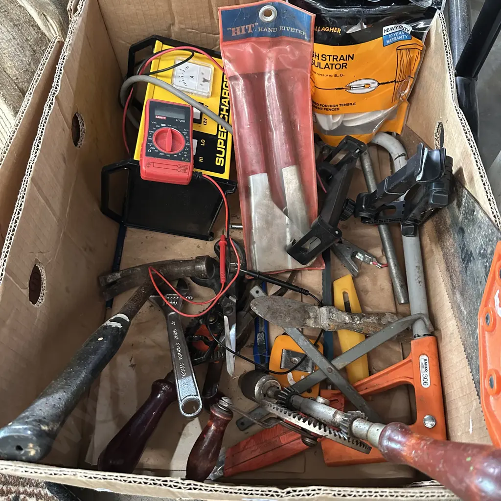 Bin of tools including multimeter and battery charger. Image 1++